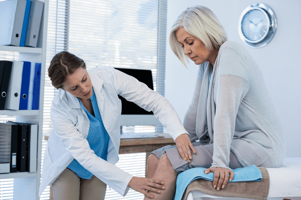 Il medico esamina un paziente con artrosi del ginocchio